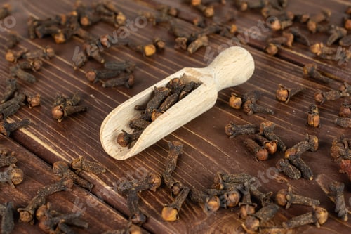 Preview: Lot Of Whole Dry Brown Clove In A Wooden Scoop On Brown Wood