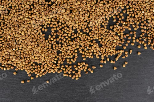 Preview: Lot Of Whole Raw Brown Buckwheat Grain Copyspace Flatlay On Grey Stone