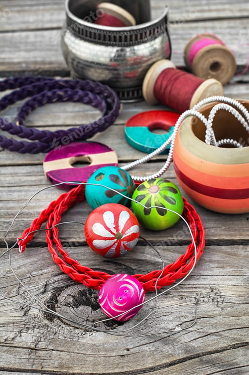 Preview: Stylish Beads And Spools Of Thread On Wooden Background