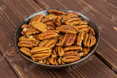 Preview: Lot Of Whole Dry Brown Pecan Nut In Dark Ceramic Bowl On Brown Wood