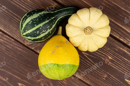 Preview: Group Of Three Whole Beautiful Decorative Gourd Flatlay On Brown Wood