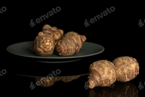 Preview: Group Of Six Whole Fresh Brown Jerusalem Artichoke On Gray Ceramic Plate Isolated On Black Glass