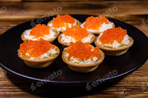 Preview: Tartlets With Red Caviar On Black Plate. Festive Food