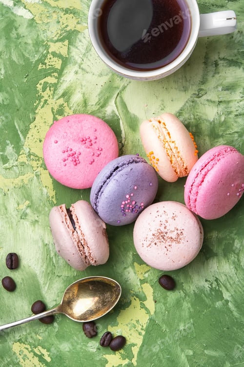 Preview: Coffee And Colorful French Macaroons On Green Background