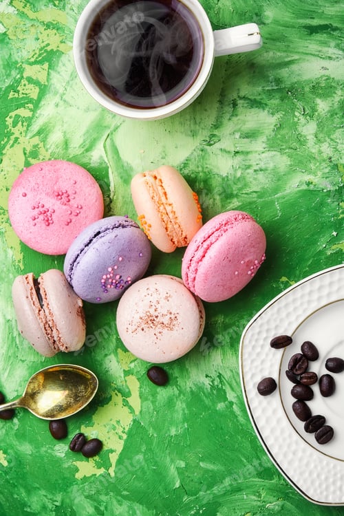 Preview: Coffee And Colorful French Macaroons On Green Background