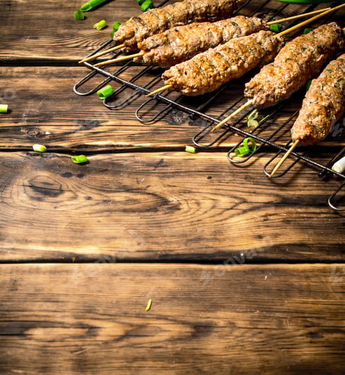 Vista previa: Kebab On The Grill With Green Onions. On A Wooden Table.