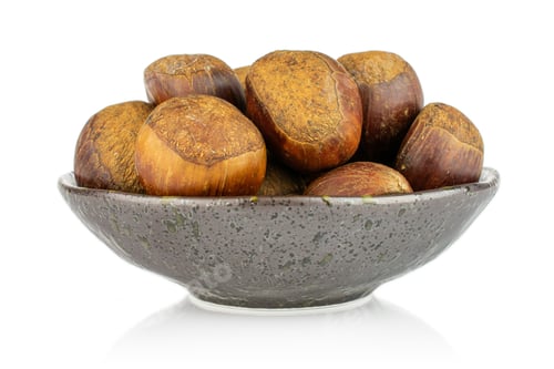 Preview: Lot Of Whole Sweet Brown Chestnut In Dark Ceramic Bowl Isolated On White Background