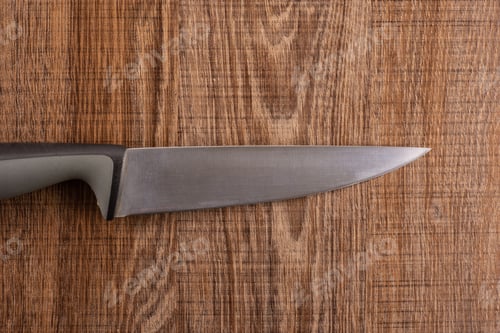 Preview: One Whole Kitchen Tool Stainless Steel Chef Knife With Grey Plastic Handle Flatlay On Brown Wood
