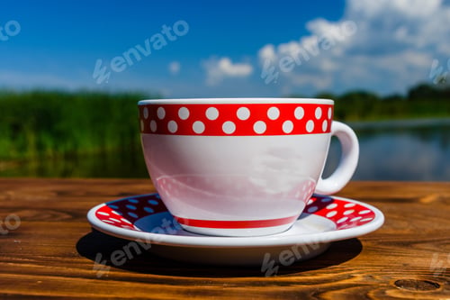 Preview: Cup Of Coffee On Rustic Wooden Table At The Riverside