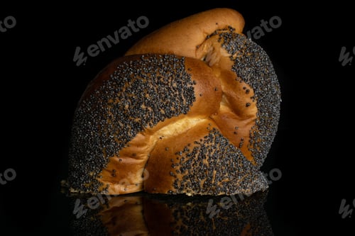 Preview: One Half Of Twisted Poppy Seed Bun Isolated On Black Glass