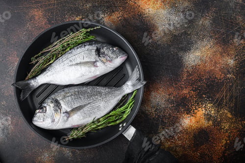 Preview: Raw Sea Bream Or Dorado Raw Fish On Grill Pan With Ingredients On Old Metall Dark Background, Top