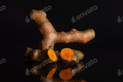 Preview: Group Of One Whole Two Halves Of Bright Turmeric Rhizome Isolated On Black Glass