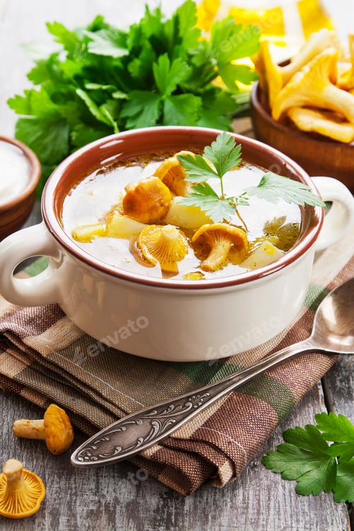 Preview: Soup With Chanterelles In A Ceramic Plate And Fresh Mushrooms On A Wooden Table