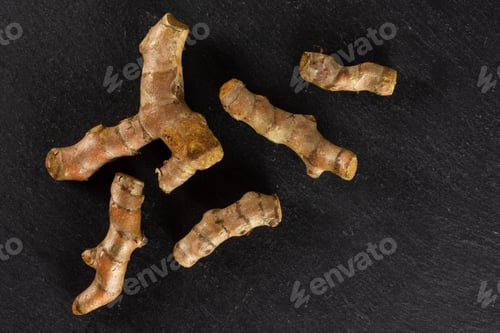 Preview: Group Of Five Whole Bright Turmeric Rhizome Flatlay On Grey Stone