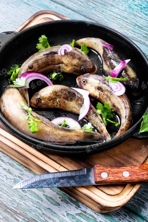 Preview: Fresh Sea Fish In A Frying Pan On The Kitchen Table.Gobiidae Fish