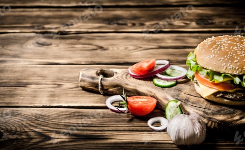 Preview: Hamburger With Tomatoes, Onions And Meat On The Board. On Wooden Background.