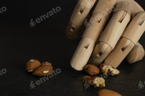 Preview: Lot Of Whole Brown Almond Nut Heap With Wooden Arm Isolated On Grey Stone