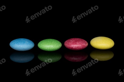 Preview: Group Of Four Whole Sweet Colourful Candy Isolated On Black Glass