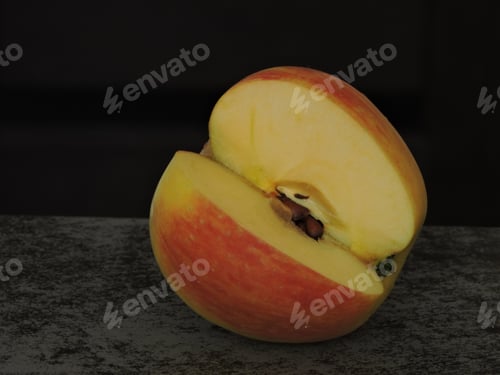 Preview: A Sliced Apple With Seeds On A Black Background. Macro.
