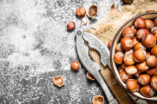 Preview: Hazelnuts In A Bowl With A Nutcracker. On Rustic Background.