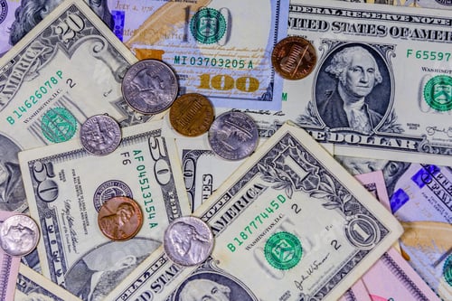 Preview: Different American Cent Coins Over Dollar Banknotes