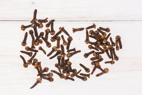 Preview: Lot Of Whole Small Dried Cloves Spice Flatlay On White Wood