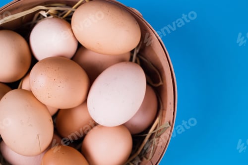 Preview: Basket Of Colored Eggs On A Blue Background In Studio