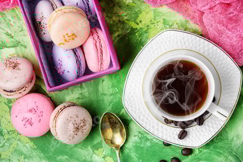 Preview: Coffee And Colorful French Macaroons On Green Background