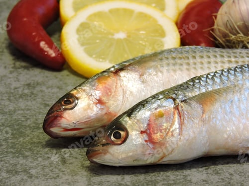 Preview: Two Raw Fish And Lemon. Mullet Lemon Garlic. Close Up.