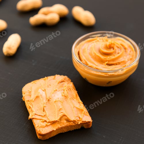 Preview: Bowl Of Peanut Butter, Unshelled Peanuts On A Dark Background, Side View. Close-Up.