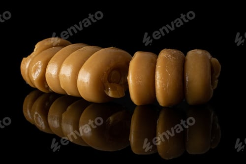 Preview: Lot Of Whole Arranged Caramel Brown Candy Heap Isolated On Black Glass
