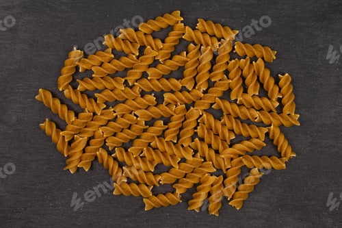 Preview: Lot Of Whole Dry Brown Wholegrain Fusilli Flatlay On Grey Stone
