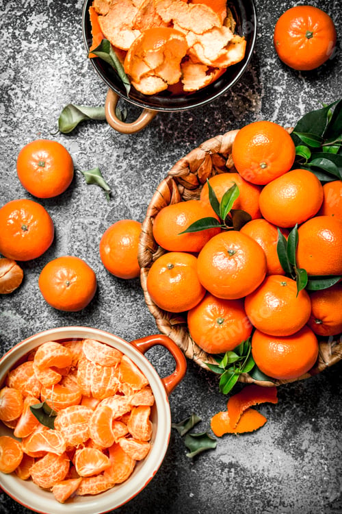 Preview: Ripe Peeled Tangerines With Green Leaves. On Rustic Background.