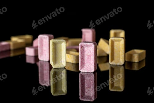 Preview: Lot Of Whole Arranged Sweet Pastel Candy Isolated On Black Glass
