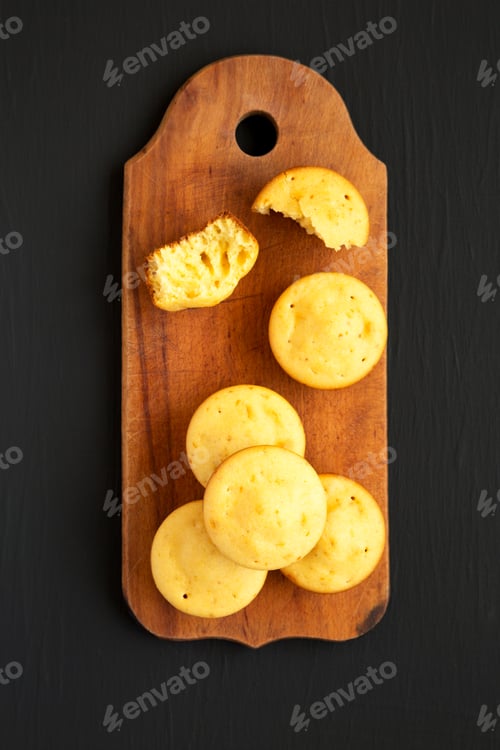 Preview: Homemade Cornbread Muffins On A Rustic Wooden Board On A Black Background, Top View. Flat Lay