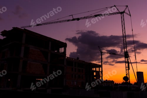 Preview: Silhouettes Of Building Cranes At Construction Site. Real Estate Buildings Under Construction On