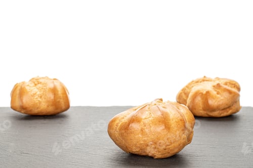 Preview: Group Of Three Whole Baked Golden Profiterole On Grey Stone Isolated On White Background