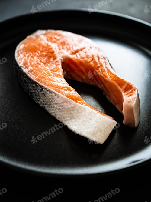 Preview: Fresh Raw Salmon Steaks With Salt On Plate On Wooden Black Table