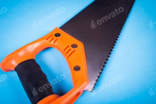 Preview: Hacksaw With Orange Plastic Handle On The Blue Surface In The Studio