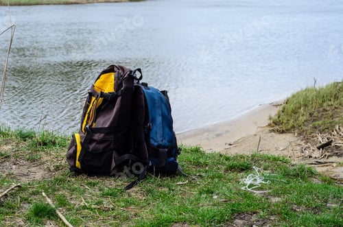 Preview: Backpacks On A Green Bank Of The River