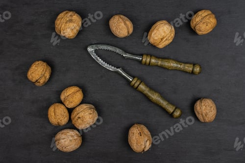 Preview: Lot Of Whole Ripe Brown Walnut With Old Nutcracker Flatlay On Grey Stone