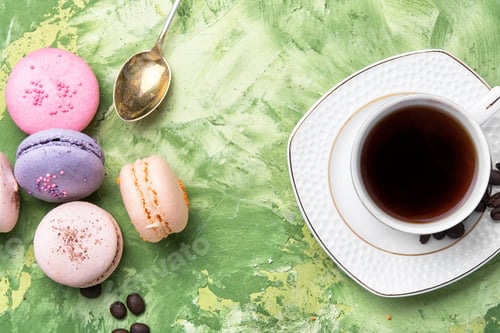 Preview: Coffee And Colorful French Macaroons On Green Background