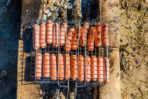 Preview: Sausages Cooking In Barbecue Grill On Campfire