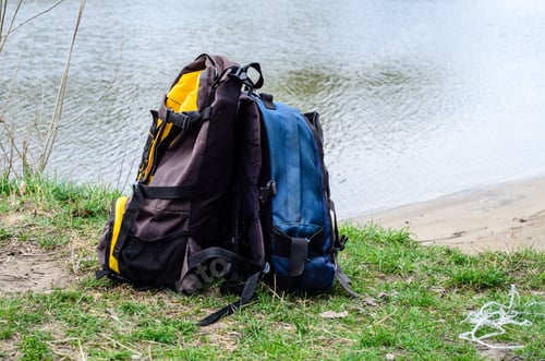 Preview: Backpacks On A Green Bank Of The River