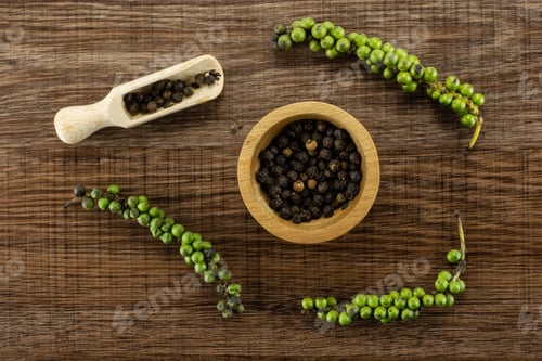Preview: Unripe Drupes Of Fresh Black Pepper Flatlay On Brown Wood Backgound Four Bunches One Wooden Bowl