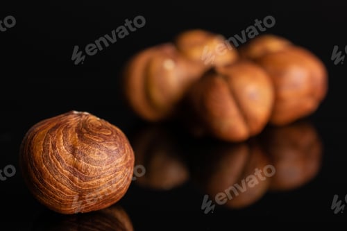 Preview: Lot Of Whole Ripe Brown Hazelnut In Closeup Isolated On Black Glass