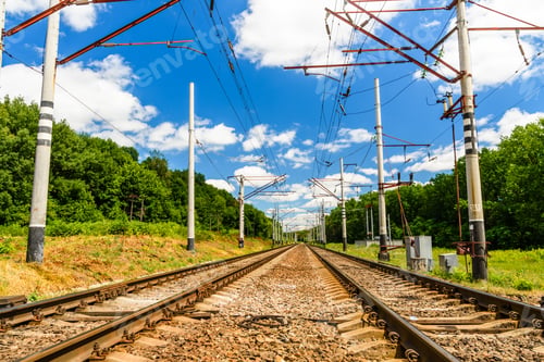 Vorschau: Blick auf eine Eisenbahnstrecke und weiße Wolken am blauen Himmel