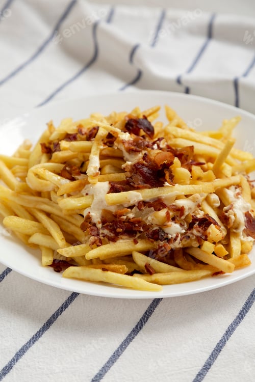 Preview: French Fries With Cheese Sauce And Bacon On A White Plate, Side View. Closeup.