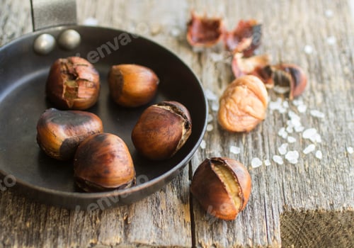 Preview: Roasted Chestnuts On Wooden Table With Coarse Salt
