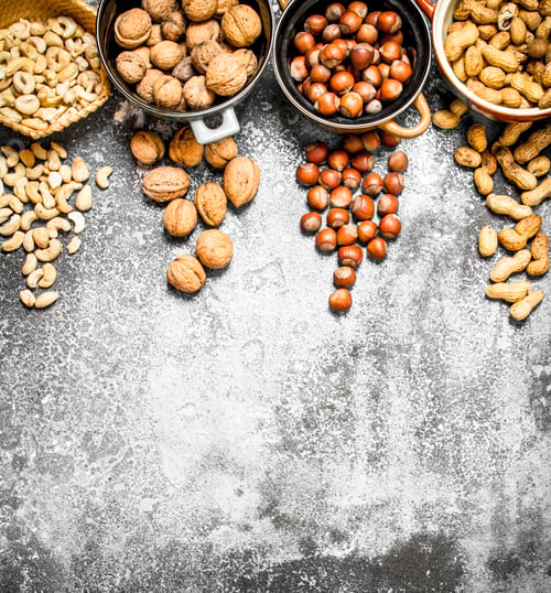 Preview: A Lot Of Nuts In Different Bowls. On Rustic Background.
